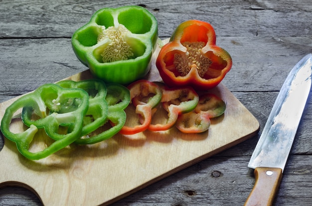 Photo of sliced colorul peppers over wooden table