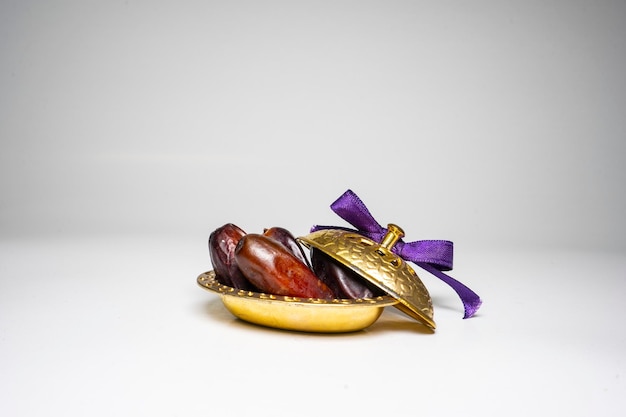 photo a small bowl of dates next to a handful on white background. high quality photo