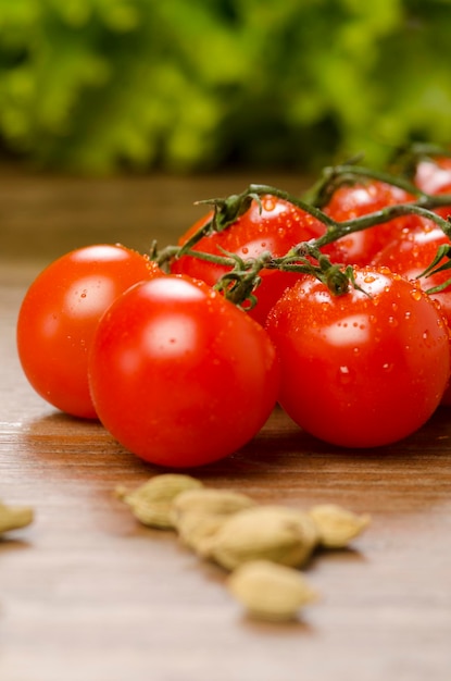 Photo of small cherry tomatoes on the table against the background of green