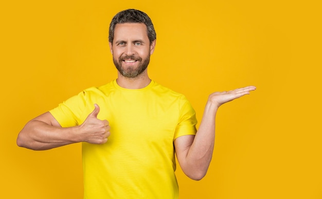 Photo of smiling man presenting advertisement thumb up man presenting advertisement