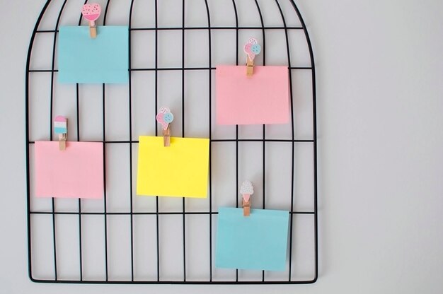 Photo of stacks of colorful stickers and torn paper from a\
notebook, pinned to a blackboard. yellow sticky stickers to remind\
you of the information. space for text.