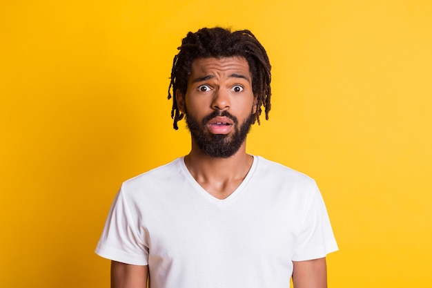 Photo of staring dark skin guy open mouth listen unexpected terrible news wear casual t-shirt isolated yellow color background