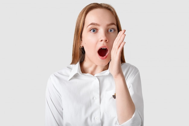 Photo of surprised woman exclaims loudly