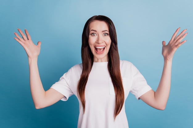 Photo of surprised young woman isolated over blue background