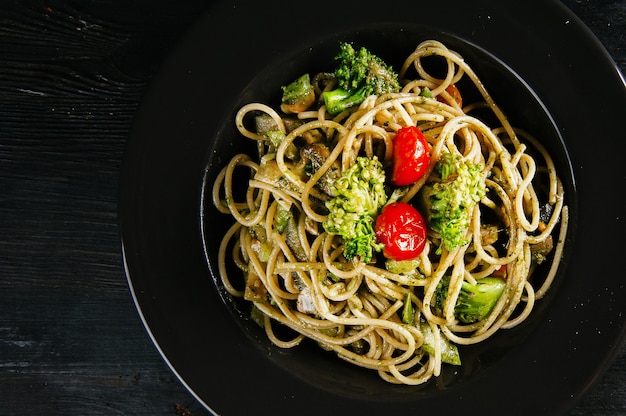 Photo of tasty healthy Italian pasta with broccoli and tomatoes