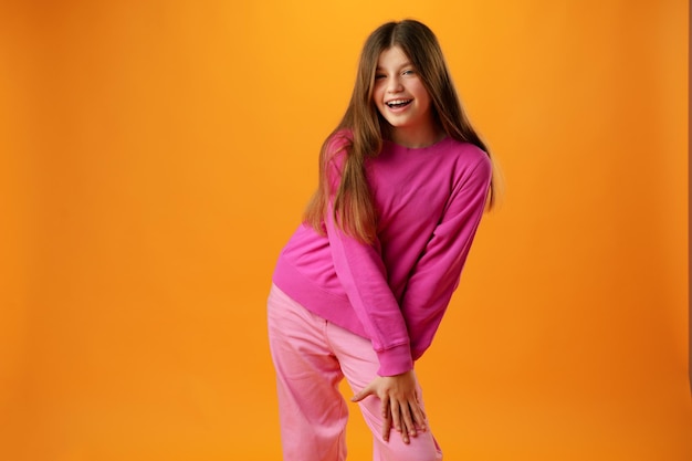 Photo photo of teen girl smiling portrait against yellow background in studio