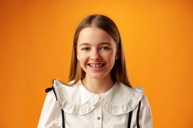Photo photo of teen girl smiling portrait against yellow background in studio