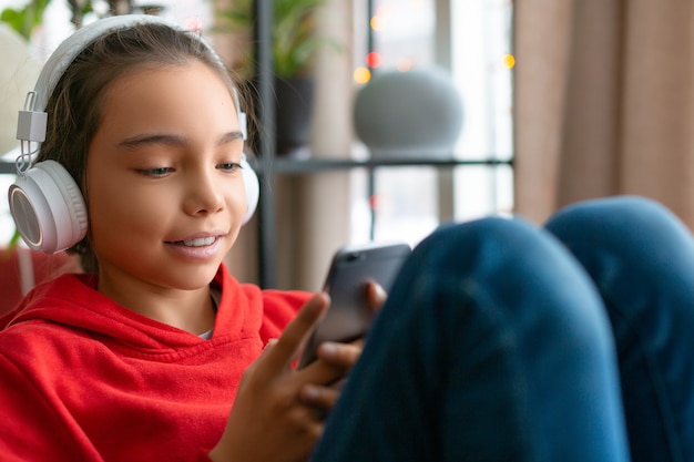 Photo of a teenager girl in headphones during online chatting with friends