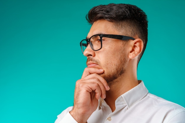 Photo of thoughtful young man touching his chin close up