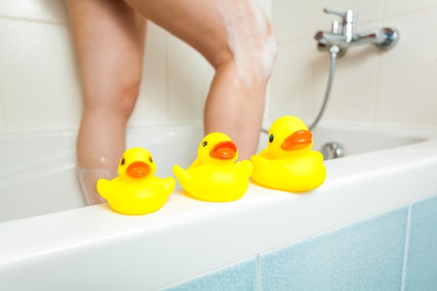 Photo of three rubber ducks at bathroom with woman having shower