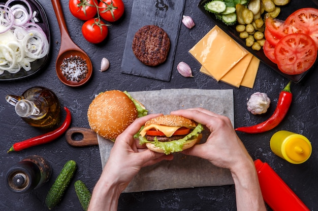 Photo on top of two hamburgers, human hands, chili peppers,