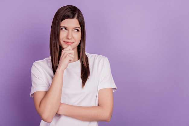 La foto di una donna ingannevole che sembra uno spazio vuoto pensa che il mento del dito abbia isolato lo sfondo viola