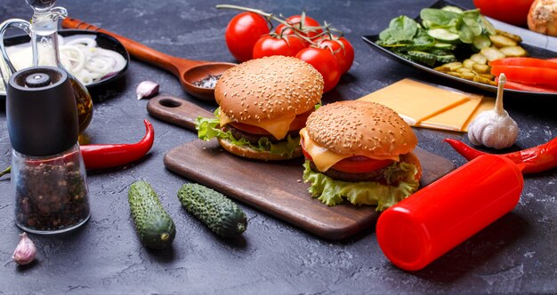 Photo of two hamburgers on wooden board, cheese