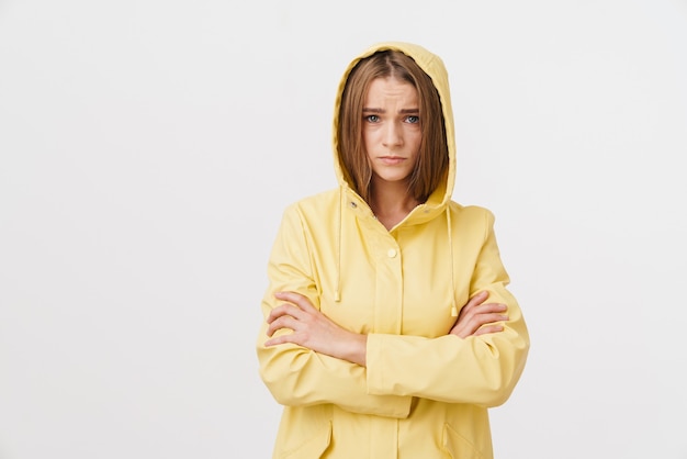 Photo of unhappy caucasian woman in raincoat posing and looking at camera 