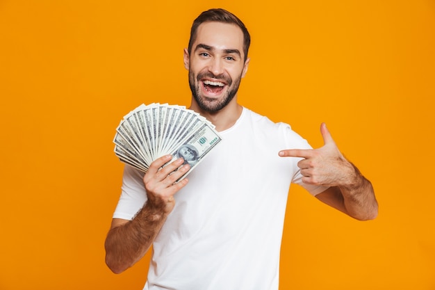Photo of unshaved man 30s in casual wear holding bunch of money, isolated