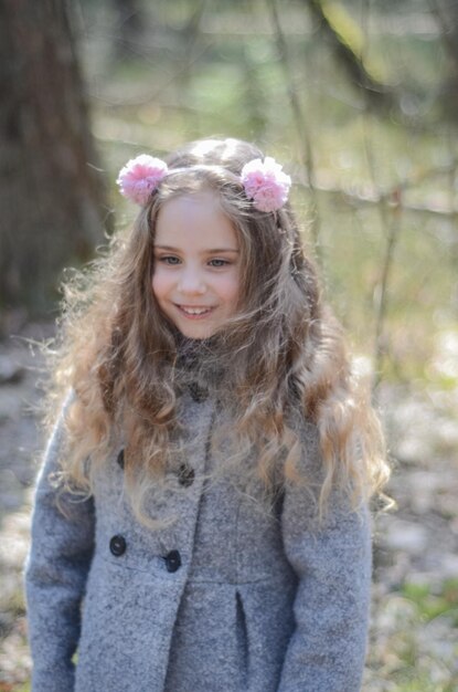 Photo of vintage style dressed little girl playing in the forest