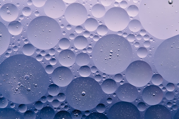 Photo of Water oil bubble macro abstract background, flow liquid in blue, purple, dark white, aqua colors