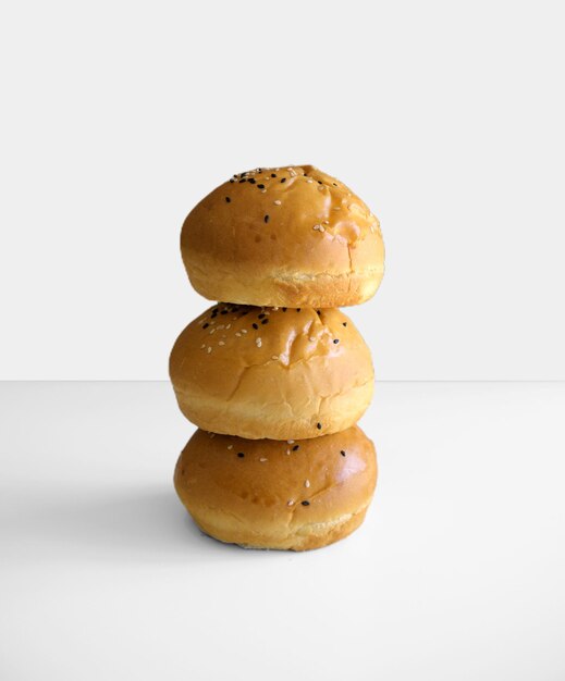 Foto foto di un panino rotondo intero con semi di sesamo isolati su sfondo bianco