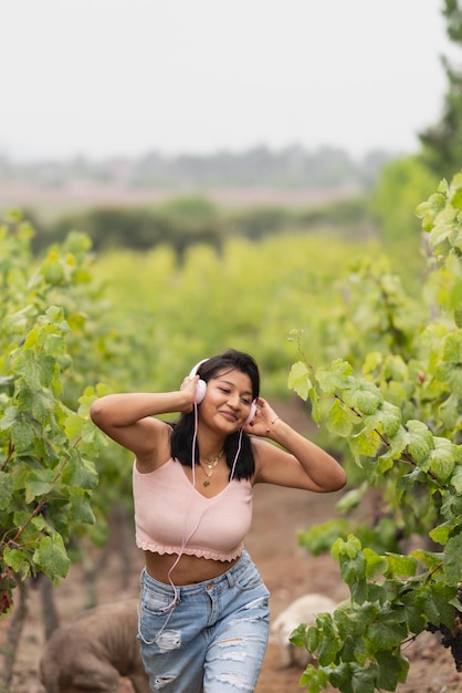 Photo with copy space of a girl listening to music in the middle of a vineyard