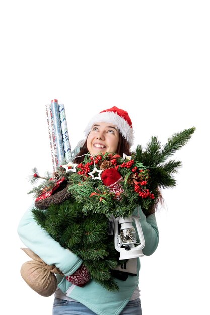 Photo photo of woman in santas cap with christmas tree lantern wrapping paper in hands