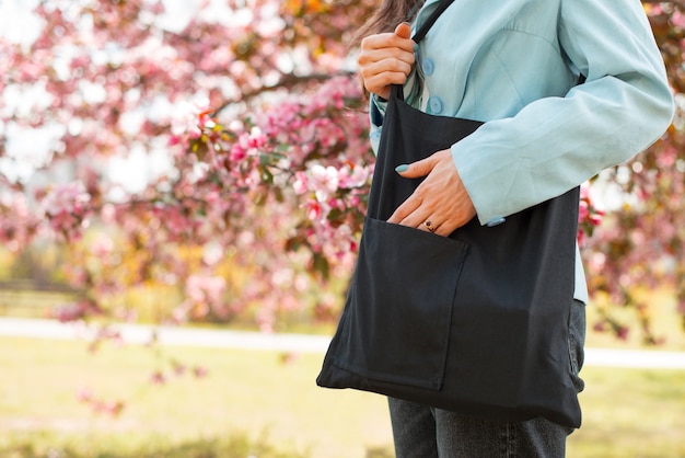 Foto di una donna che usa una borsa di materiale riutilizzabile all'aperto