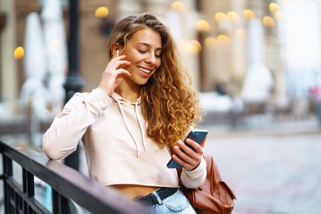 Photo photo of woman using smart phone beautiful woman texting on street woman spending time in city