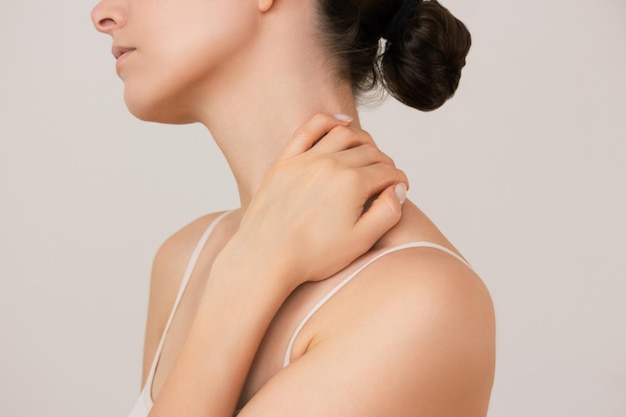 photo of woman who holding her hand around her neck experiencing pain from osteochondrosis fatigue