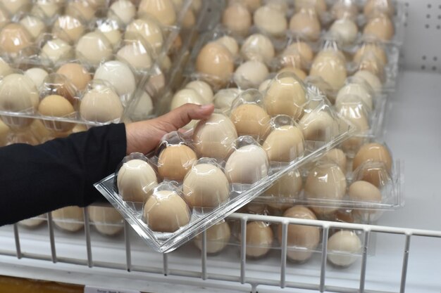 Photo photo of women hand picking up eggs for groceries