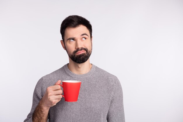 Photo of wondered guy look empty space dream drink hot americano minded isolated on grey color background