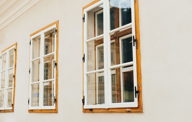 Photo of wooden windows in perspective on a white wall.