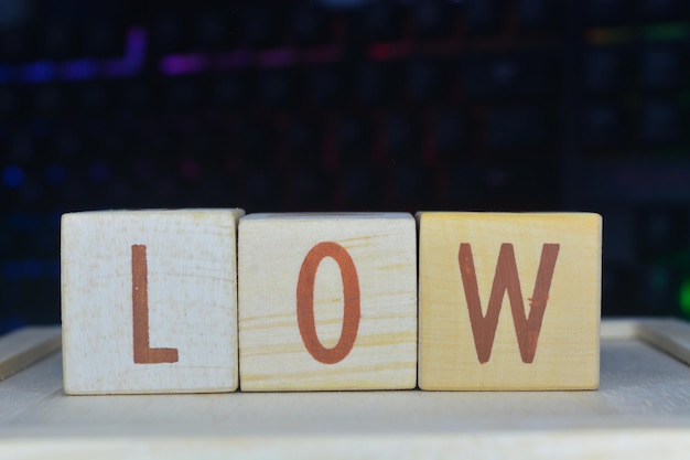 Photo photo of words with wooden block objects arranged into the word low in english