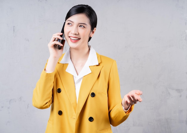 Photo of young Asian businesswoman holding phone