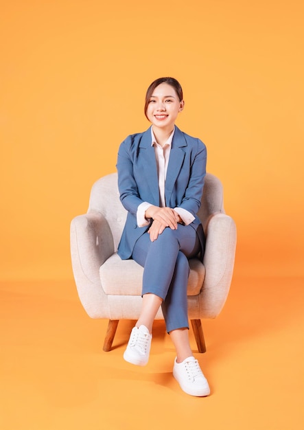 Photo of young Asian businesswoman sitting on armchair