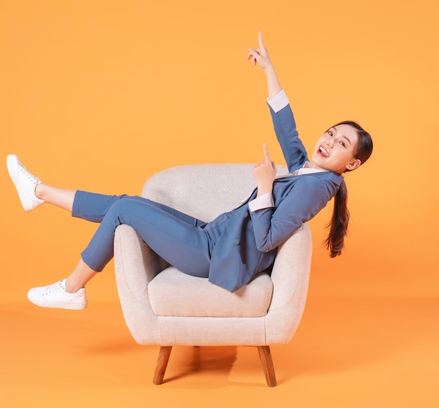 Photo of young Asian businesswoman sitting on armchair