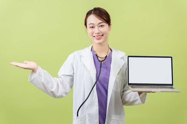 Photo of young Asian femle doctor on green background