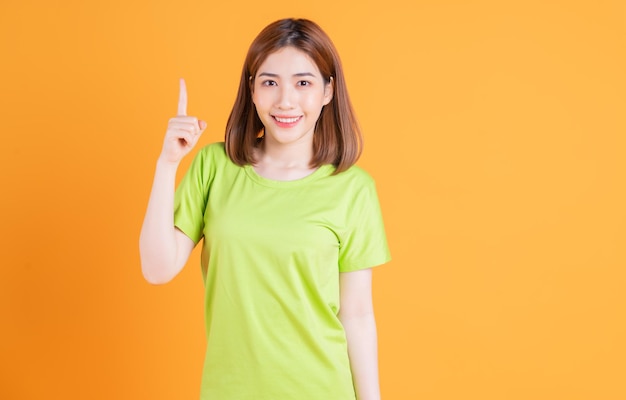 背景にポーズをとって若いアジアの女の子の写真