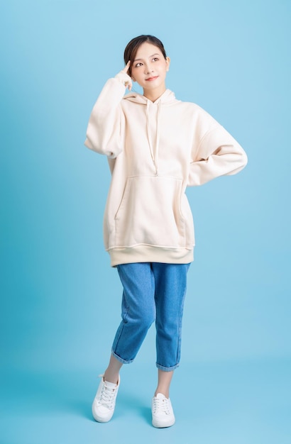 Photo of young asian girl posing on blue background