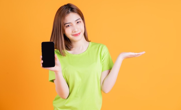 背景にスマートフォンを使用して若いアジアの女の子の写真