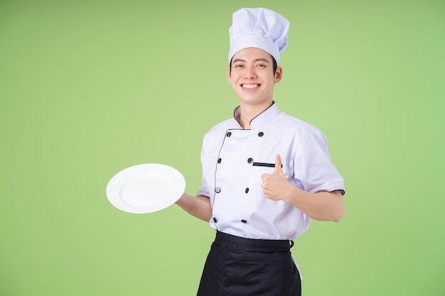 Photo of young Asian male chef on background