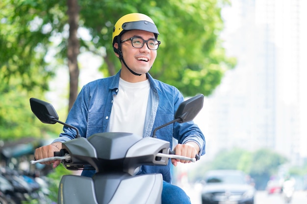 バイクを運転する若いアジア人男性の写真