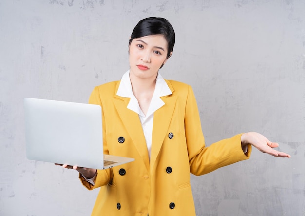 Photo of young Asian woman holding laptop