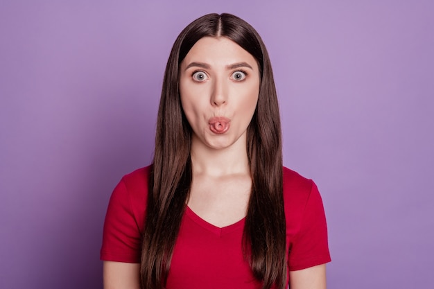 Photo of young attractive funky girl fooling grimace tongue-out isolated over violet color background