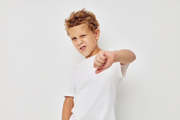 Photo of young boy in a white tshirt posing fun isolated background