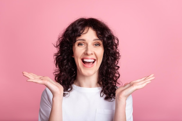 Photo of young cheerful pretty girl good mood hold arms news discount isolated over pink color background