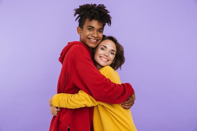 Photo of young couple friends students standing isolated, hugging.