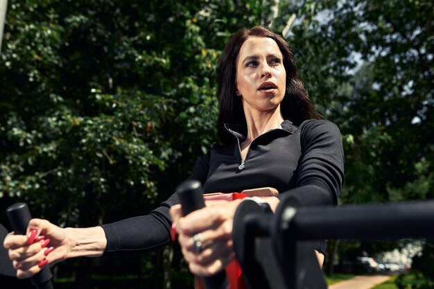 Photo of young european woman on a street workout in sports\
park on sunny day