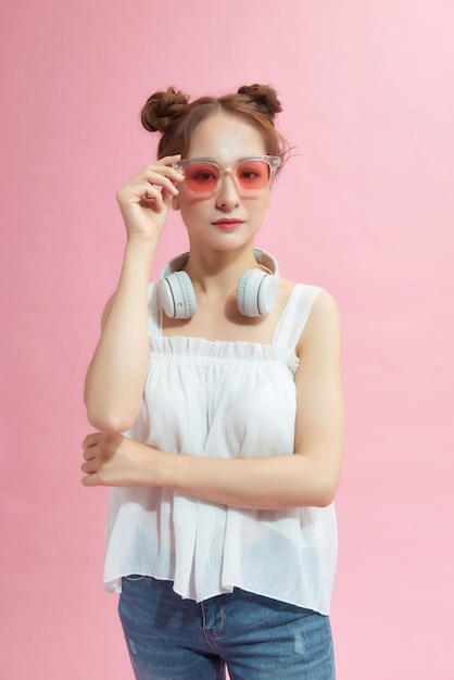 Photo of young excited  girl happy positive smile hands touch sunglass isolated over pink color background