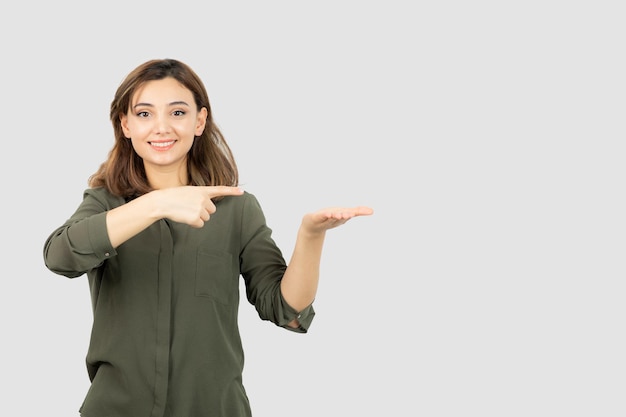 Foto di giovane ragazza in abito casual in piedi e guardando