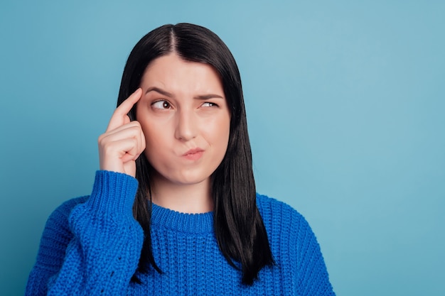 Photo of young girl look empty space think minded deep forget memory isolated on blue color background