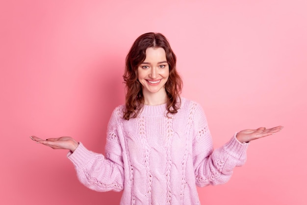 Photo of young girl promoter hold hands proposition scales vs ads isolated over pink color background.